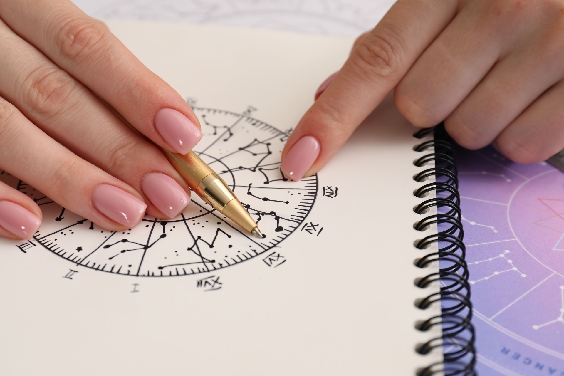 Astrologer using zodiac wheel for fate forecast at table, closeup. Fortune telling